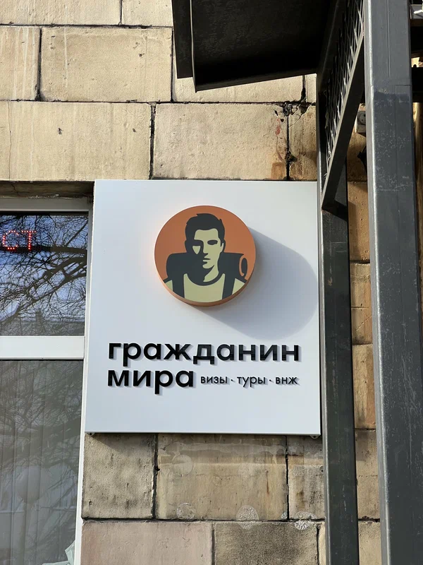Вывеска «Гражданин Мира — визы, туры, ВНЖ» у входа в офис